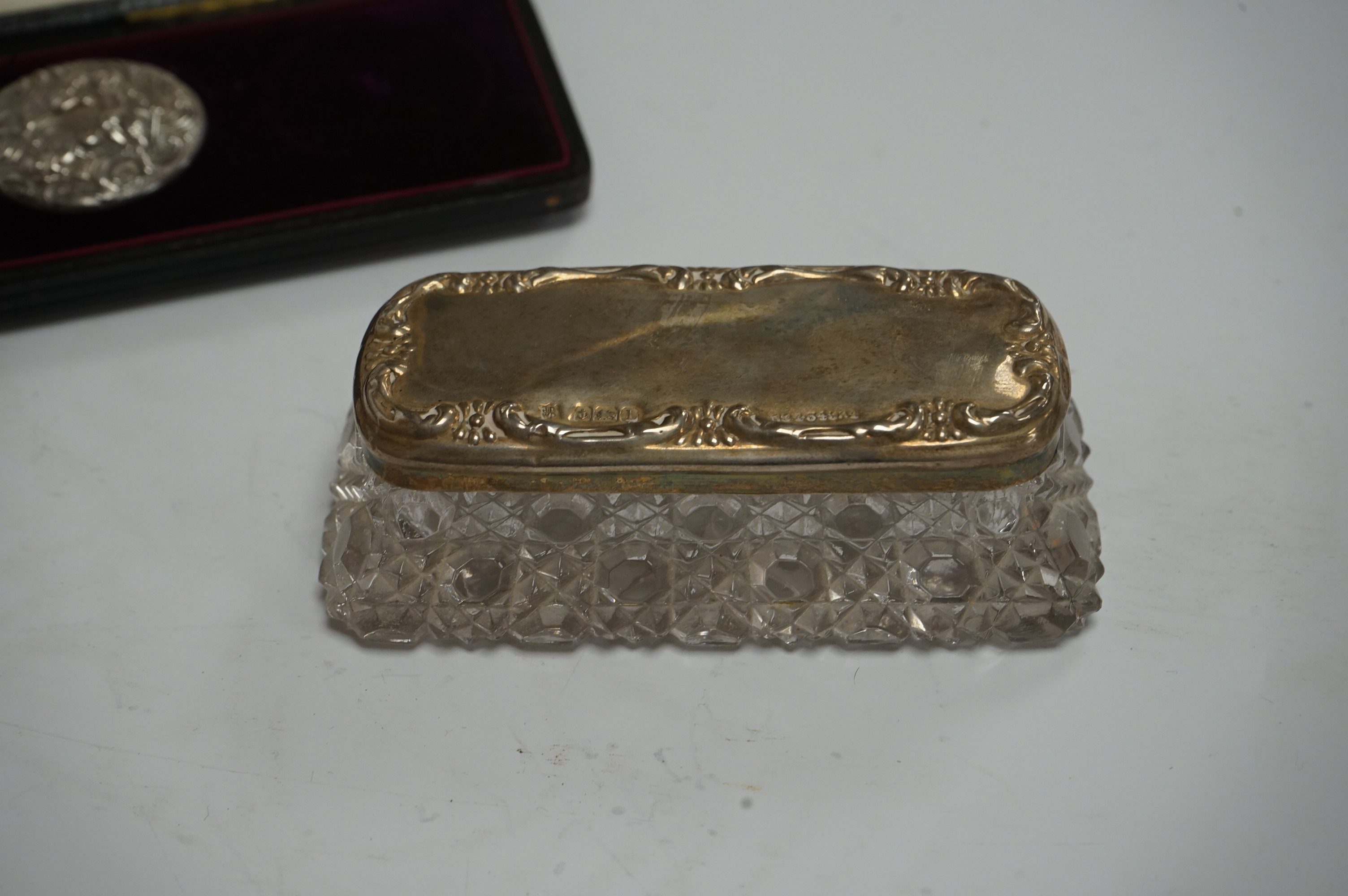 A cased set of five(ex 6) Edwardian repousse silver buttons, import marks for London, 1902, 33mm, a modern wooden handled silver extinguisher, six assorted Victorian and later silver mounted glass toilet jars and a cased